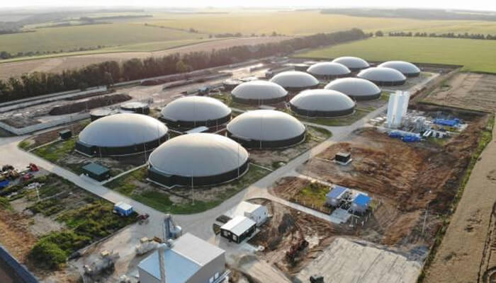 Million grant Aerial view of a large biogas facility with multiple domes and industrial equipment, representing sustainable energy infrastructure.