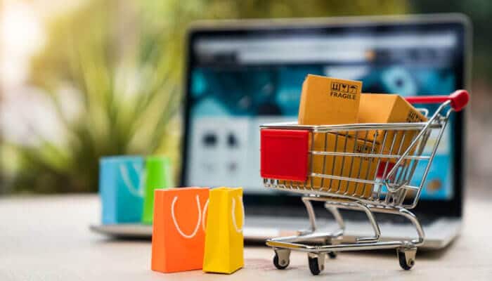 Online socially conscious marketplace - tycoonstory | tycoonstory media Online shopping cart with laptop in background, symbolizing e-commerce activities run by a social enterprise.