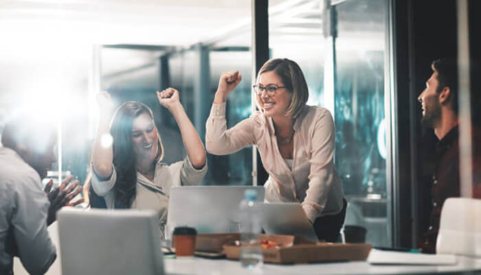 Successful women Team celebrating a win in the office with female leaders showing confidence and success, representing successful women in tech.
