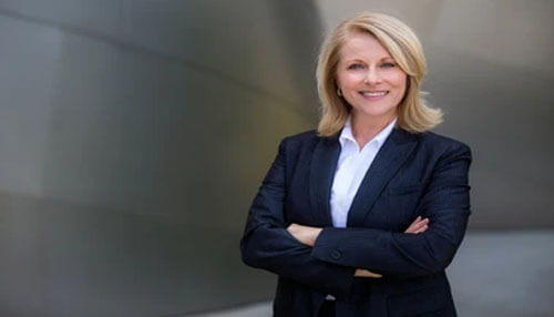 Traits of successful entrepreneurs Confident businesswoman in a navy suit standing with arms crossed and smiling, representing the traits of successful entrepreneurs such as leadership, confidence, and professionalism.