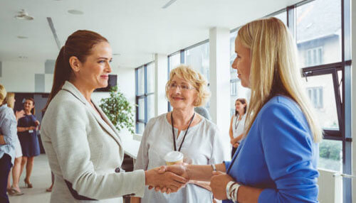 Female entrepreneurs Female entrepreneurs building partnerships and professional relationships at a corporate networking event.