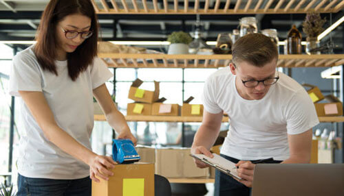 Logistics partner ecommerce - tycoonstory | tycoonstory media Warehouse staff packing and scanning boxes for shipment, representing efficient order fulfillment by a logistics partner for ecommerce.