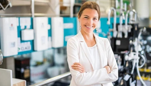 Start your own business A cheerful businesswoman standing confidently with folded arms in a modern workspace, symbolizing entrepreneurial success.