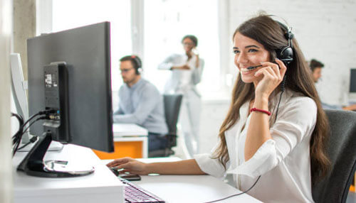 Customer service social media for business Customer support professional working at a computer with a headset, illustrating team engagement, communication, and customer interaction through social media for business platforms.