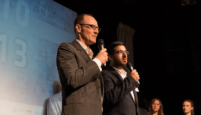 Beemgee storytellers Storytellers speaking on stage with microphones at a live event, sharing ideas and engaging an audience through powerful narratives.