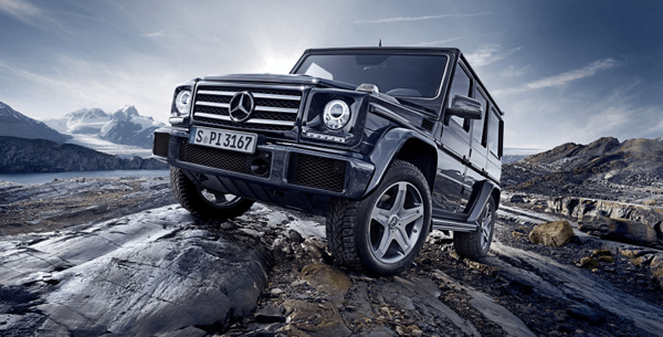 Cars for off-roading A mercedes g-class suv climbing rocky terrain with mountains in the background, highlighting premium off-road capability.
