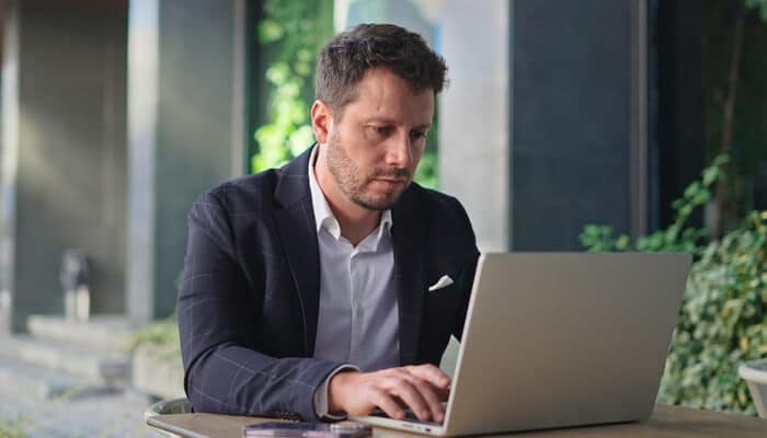 Australian startups landscape | tycoonstory media A professional man working on a laptop, representing the effort and focus needed for australian startups to navigate the impact of the new immigration law on their growth.