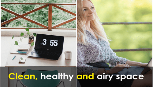 Employee-friendly office Clean and airy office space with natural elements, laptop on desk and person relaxing by window