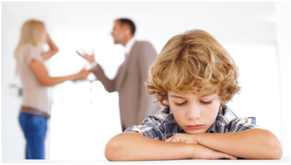 Child | tycoonstory media A sad child with their head resting on folded arms in the foreground while two adults argue in the background, illustrating the emotional impact of parental conflict in family law situations.