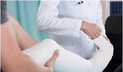 Accident insurance - tycoonstory | tycoonstory media Doctor wrapping a patient’s injured leg, highlighting the need for a personal lawyer in personal injury cases.