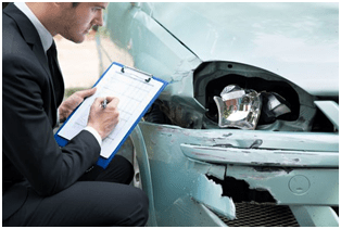 Personal injuries An insurance adjuster in a suit is inspecting a car accident, taking notes on the damage to assess potential personal injuries and compensation.