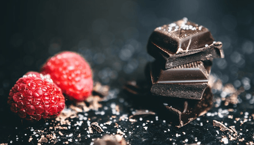 Boosting energy Dark chocolate pieces with raspberries, a healthy snack option that can contribute to boosting energy levels and providing a quick energy boost.