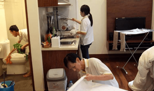 Hire a cleaning service Professional cleaning staff working in a home kitchen and bathroom after you hire a cleaning service.