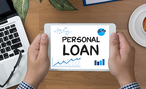 Loans online Hands holding a tablet displaying "personal loan" with financial charts and graphs, representing available online personal loans.