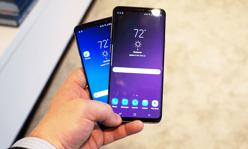 Alternative start-up ideas Close-up of a person holding two modern smartphones displaying the home screen and weather