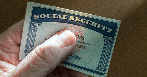 Documents Hand holding a social security card, highlighting sensitive personal information.