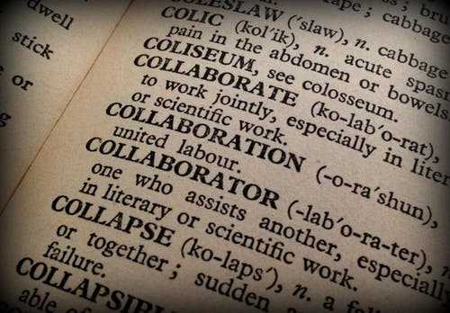 Teach english abroad Close-up view of a dictionary page highlighting the word collaboration, symbolizing teamwork and communication skills.