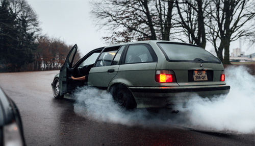 8 things you need to do if you get in a vehicular accident Car skidding on a wet road with smoke coming from the tires after a vehicular accident, showing loss of control and road safety risks.