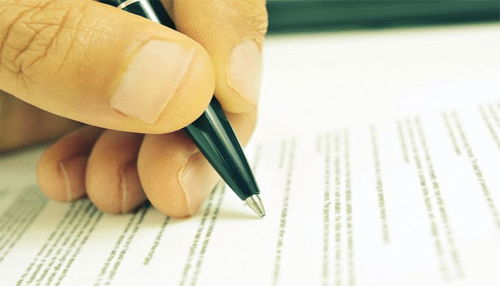 Experience lender - tycoonstory | tycoonstory media A close-up of a hand signing official paperwork, symbolizing documentation and approval processes related to usda business loans.
