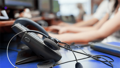 Cloud contact centre Desk phone with headset in a modern office setup, representing communication technology used in a cloud contact centre environment.
