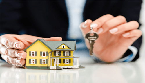 Conventional loans - tycoonstory | tycoonstory media A person holding a house model and a key, representing mortgage alternatives and rental properties in real estate decisions.