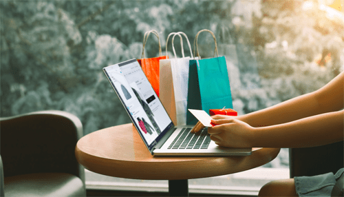 Top online shopping sites in indonesia A shopper entering payment details on a laptop, with shopping bags in the background, reflecting the growing trend of online shopping sites in indonesia