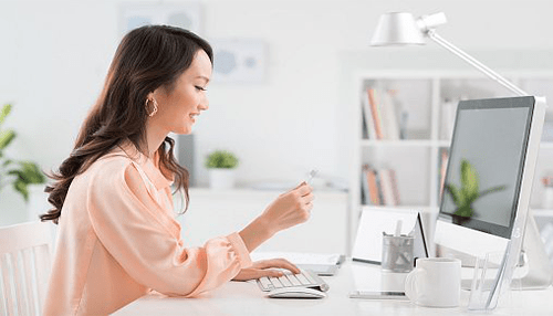 Top online shopping sites in china Woman shopping online on a desktop computer, representing the use of shopping sites in china for convenient online purchases.