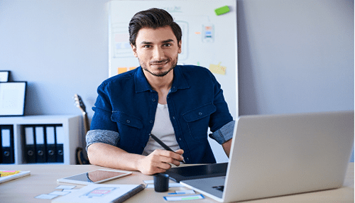 Home-based businesses Young man working on his laptop at a desk, illustrating the concept of home-based businesses.