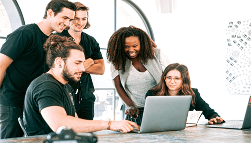 6 tips for your startup business Business team of five gathered around a laptop, sharing ideas and collaborating on a project for a successful business venture.
