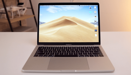 Mac A close-up of a macbook pro laptop with a sand desert wallpaper, symbolizing mac hardware design and functionality.