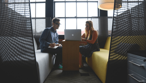 Benefits of cash equity business bootstrapping Two colleagues in a private booth reviewing a laptop, embodying lean and resourceful business bootstrapping.