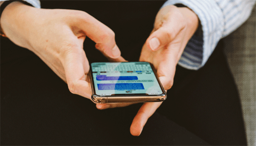 P2p texting A close-up of hands using a smartphone, sending a text message, demonstrating p2p texting as a tool for communication in political campaigns.