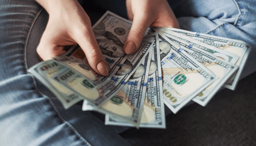 Personal finance statements A person counting stacks of money, representing the need for effective personal finance statements to manage and track financial resources