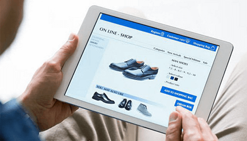 Personalized experience - tycoonstory | tycoonstory media A person shopping online on a tablet, browsing shoes on an online retail store.