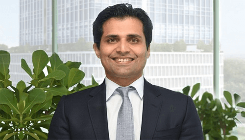 Young business tycoons Sameer gehlaut professional headshot in corporate setting with modern office background.