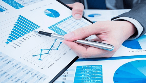 Person analyzing printed data charts and graphs, highlighting the process of reviewing business performance and sales metrics Key due diligence guidelines for reviewing financial statements