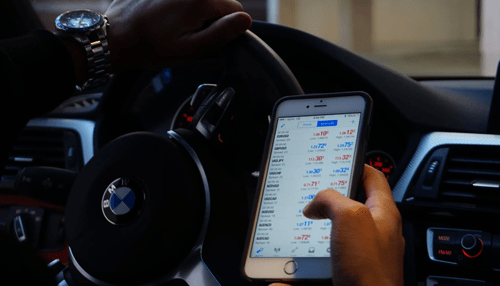 Cryptocurrency Tracking cryptocurrency market trends using a mobile phone while driving, illustrating on-the-go trading.