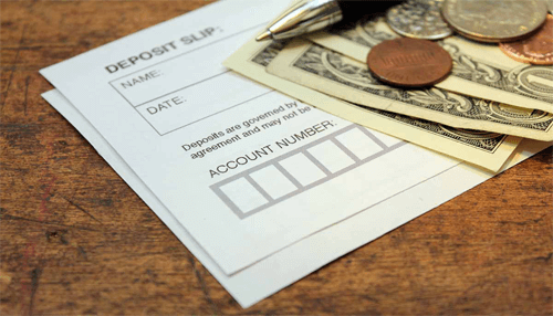 Money market instruments Bank deposit slip with cash, coins, and pen illustrating savings, banking, and money market instruments