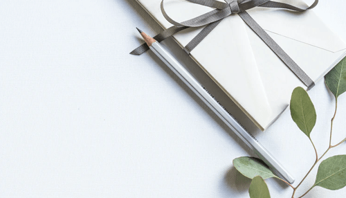 Corporate gifts Elegant corporate gifts packaging with a wrapped gift box, ribbon, pencil, and minimal stationery on a clean background.