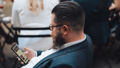 Jaspersoft Man in a suit using a smartphone for business tasks, reflecting mobile data usage with business intelligence tools.