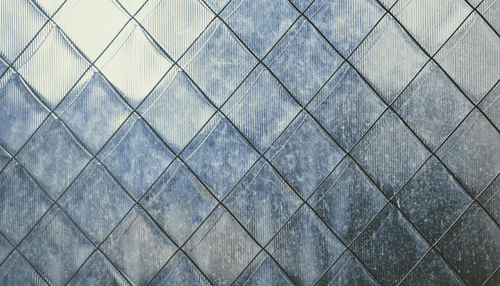 Install the bathroom tiles -tycoonstory | tycoonstory media Close-up of a textured surface with diamond-shaped patterns, showcasing a mosaic tile design with a modern aesthetic.
