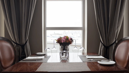 Utility bills Elegant dining table set near a window with natural light, representing household energy usage and the impact of utility bills in residential settings.
