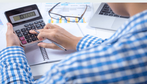 Budgeting-tycoonstory | tycoonstory media Person using a calculator to manage finances and relieve financial stress, reviewing financial documents