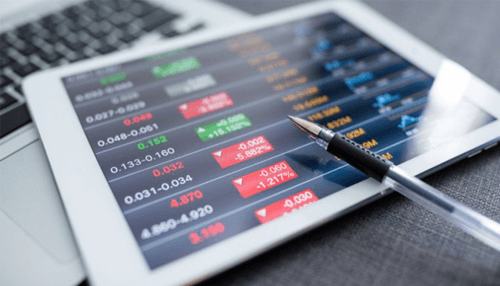 Trading markets Tablet displaying live forex market prices and fluctuations with a pen pointing at data, representing online forex trading analysis.