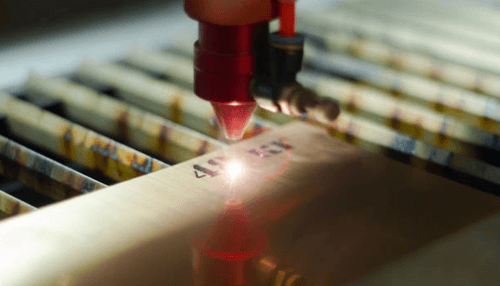 Laser photo etching - tycoonstory | tycoonstory media A close-up of a laser engraving machine at work, etching precise details onto a metal surface, demonstrating the process of photo etching.