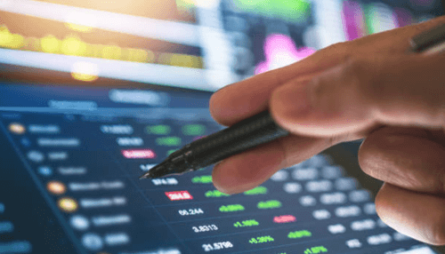 Forex trading business Close-up of a hand holding a pen, analyzing forex trading data and market trends on a digital trading platform