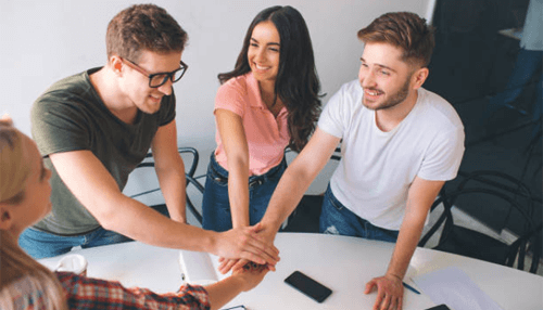 Startup accelerator Startup team stacking hands during a meeting, symbolizing collaboration, teamwork, and shared success within a startup accelerator program.