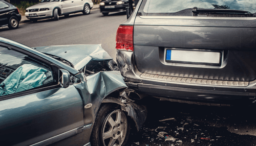 Car accident Rear-end vehicle collision on a city street, highlighting the need for a car accident lawyer to assess damage.