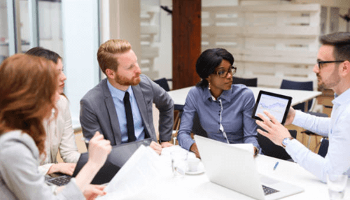 Startup accelerator Startup accelerator team discussing growth strategies while reviewing data on a tablet during a business meeting.