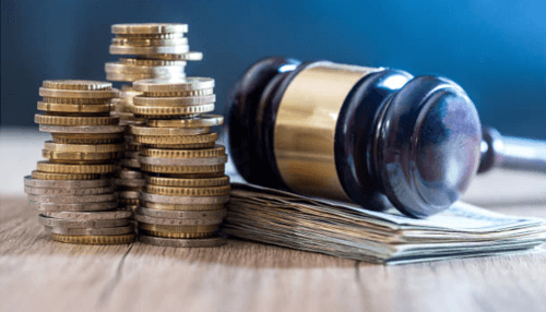 Wage law violations - tycoonstory | tycoonstory media Gavel with stacks of coins and cash representing financial penalties and legal enforcement in dss law.